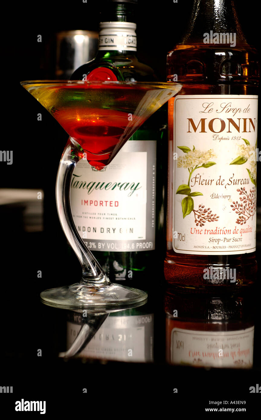 Cocktail glass filled with Tanqueray gin and Grenadine syrup in a bar