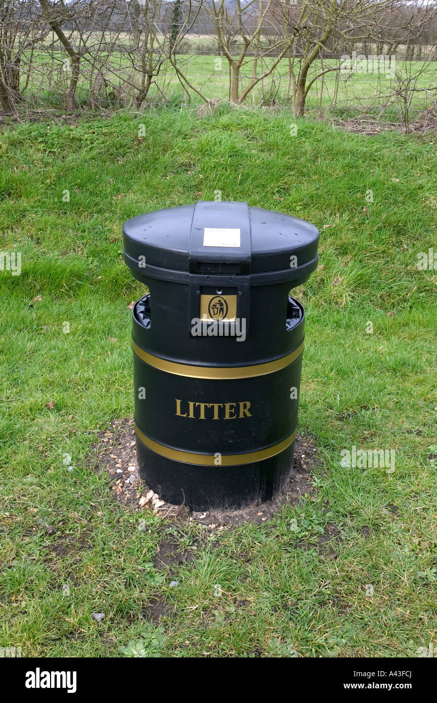 Black litter bin with gold detail in a rural setting Stock Photo