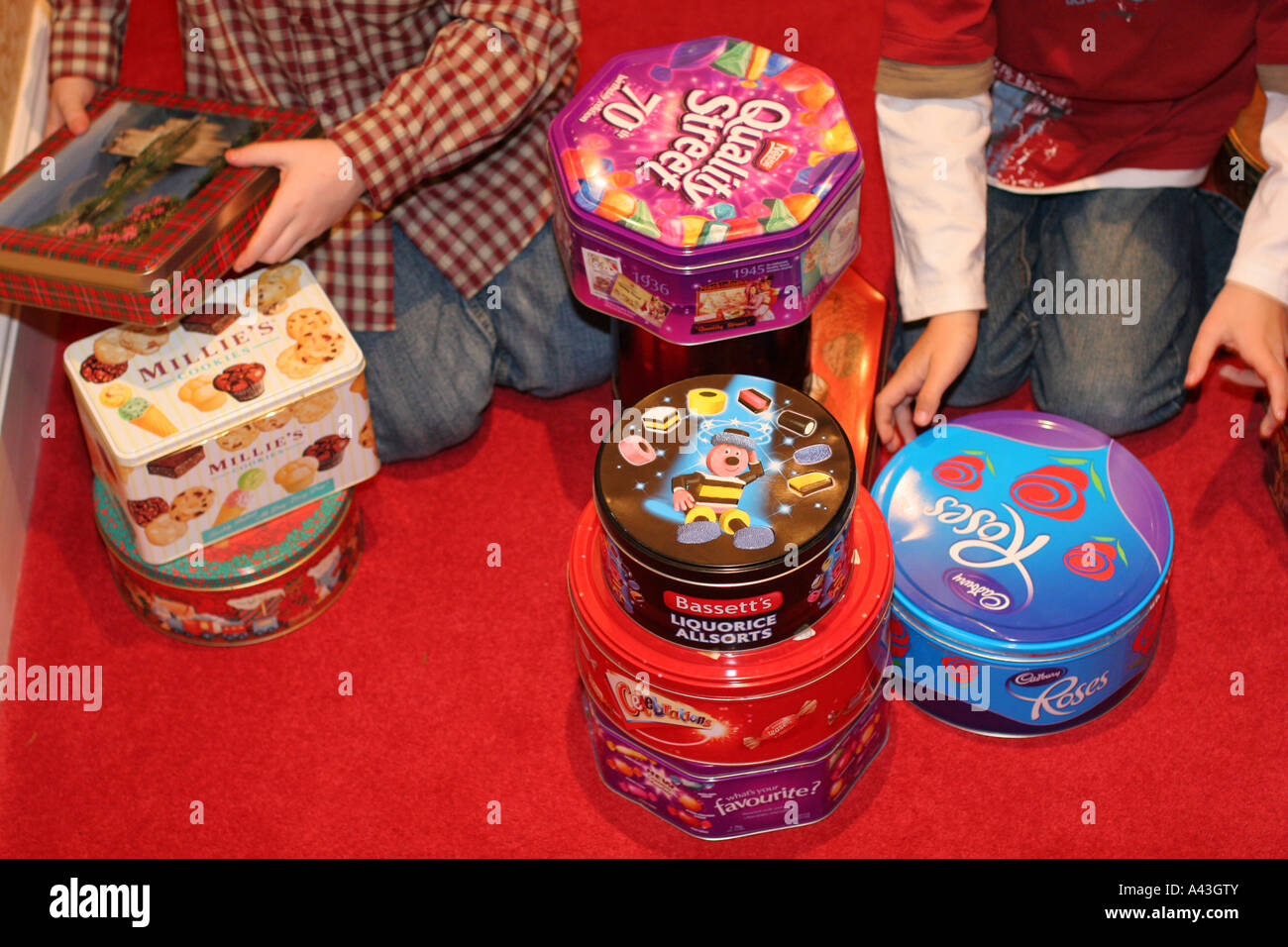 Two young children boys play with empty metal steel recyclable sweet