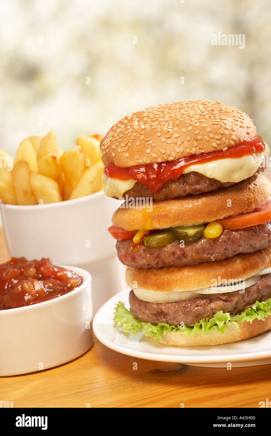 TRIPLE BEEF BURGER WITH CHEESE RELISH PICKLE SALAD ONION RELISH AND CHIPS Stock Photo Alamy