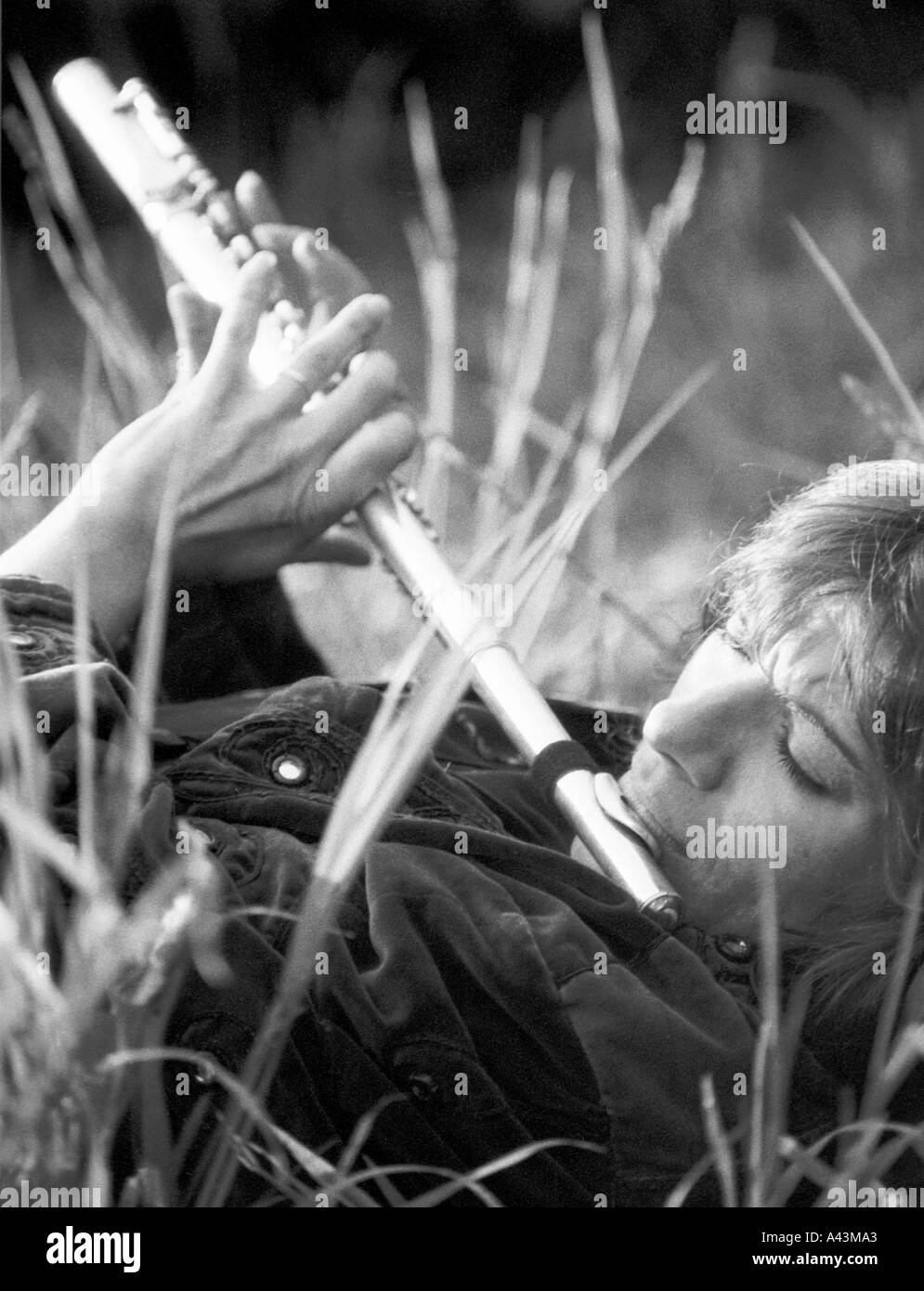 Chez Nash playing a Flute in long grass Stock Photo