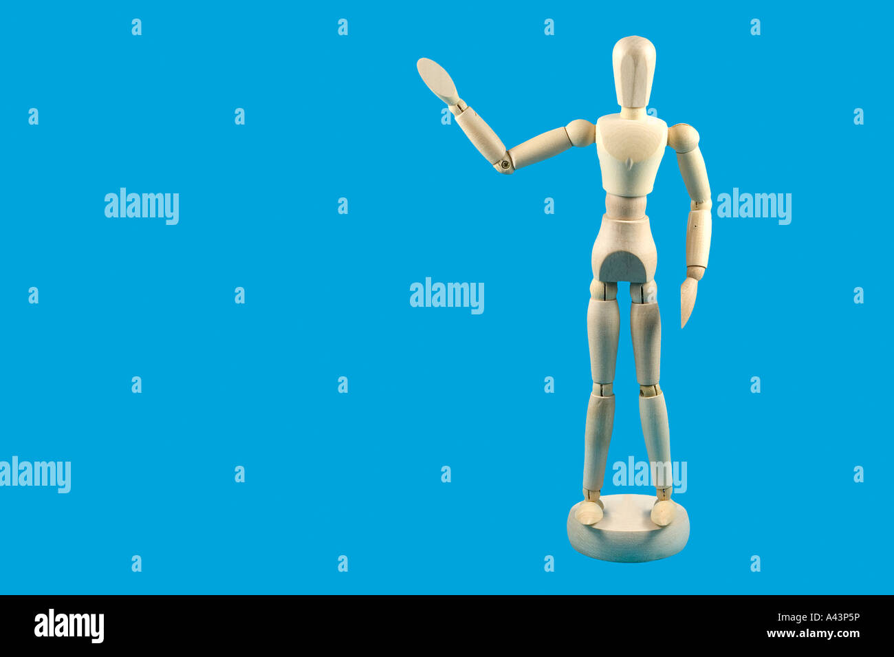 Wooden mannequin with a waving gesture isolated against a sky blue background Stock Photo