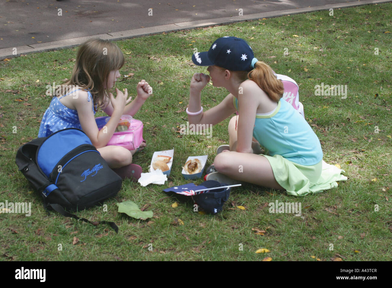 Two Girls Sitting in Park Stock Photo - Alamy