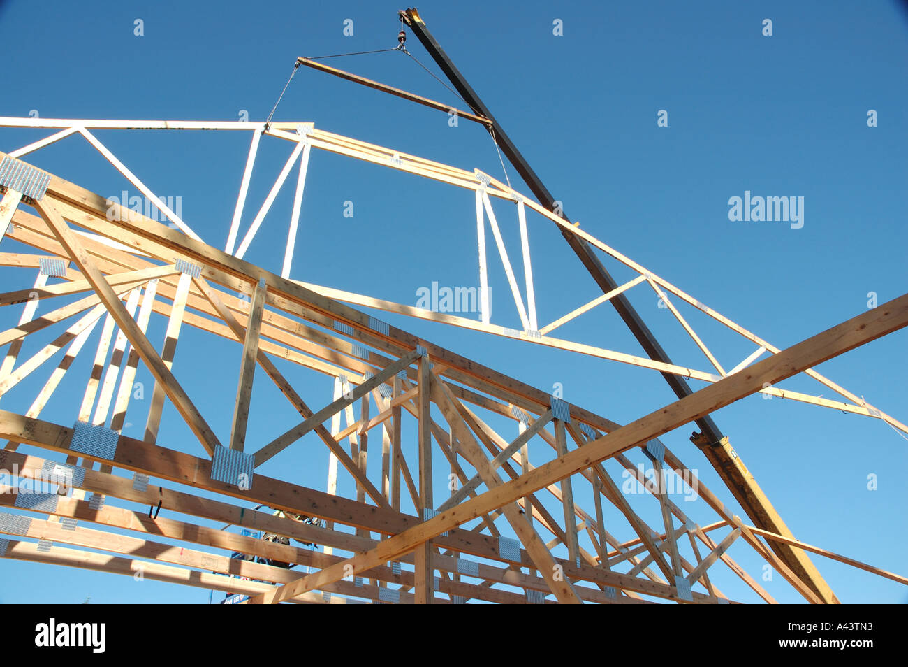 Construction Lifting A Wooden Roof Truss Into Place With Other Stock