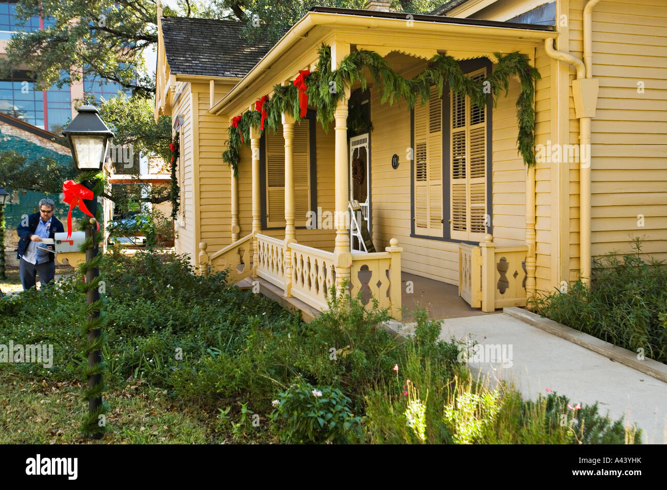 TEXAS Austin Susanna Dickinson house and museum Alamo survivor holiday garland and red bows mailman put mail in mailbox Stock Photo