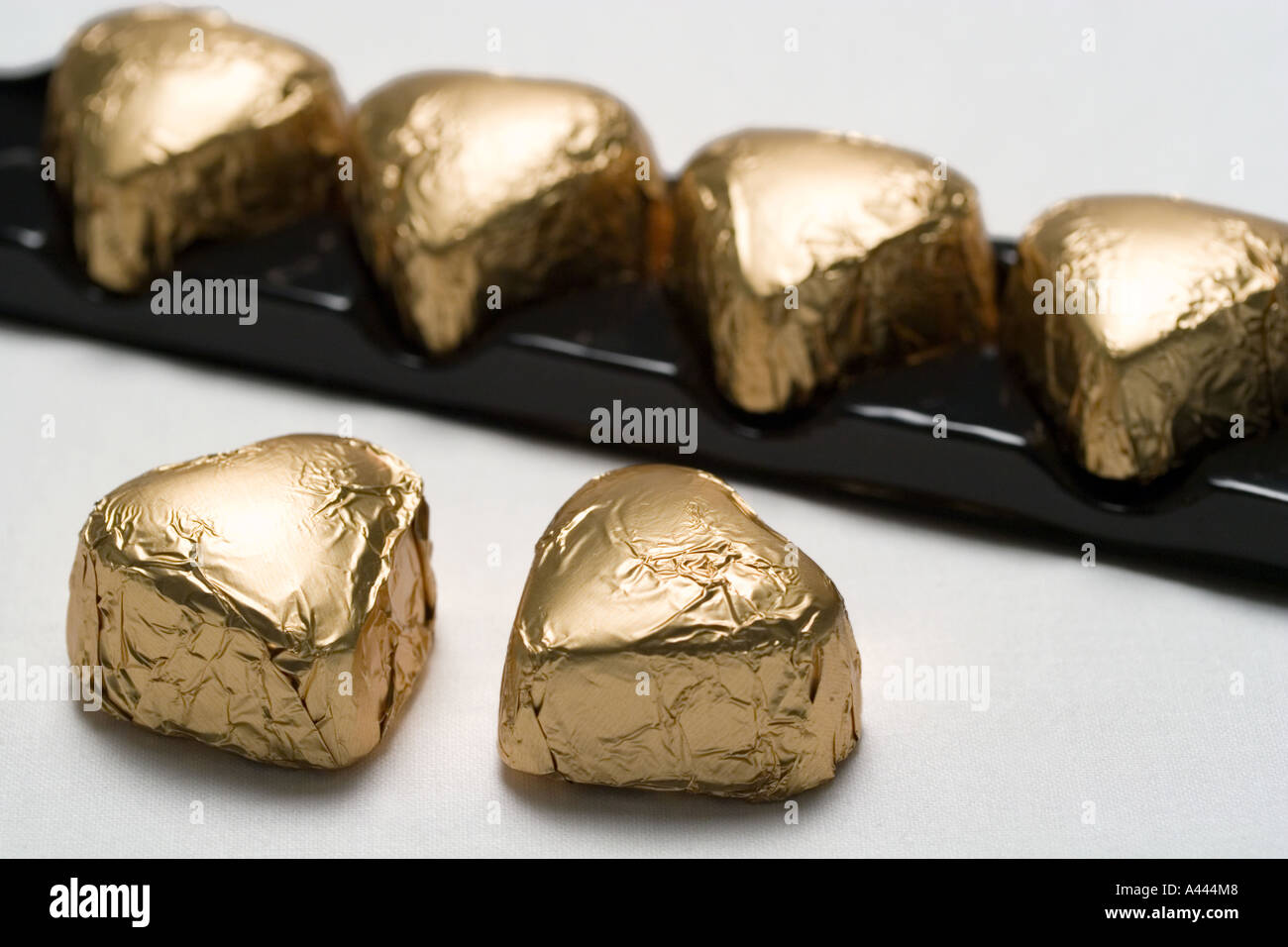 Gold foil wrapped chocolate shaped hearts Stock Photo Alamy