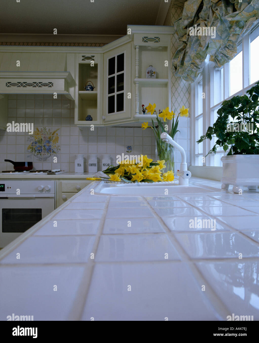 White tiled worktop in white eighties kitchen Stock Photo Alamy