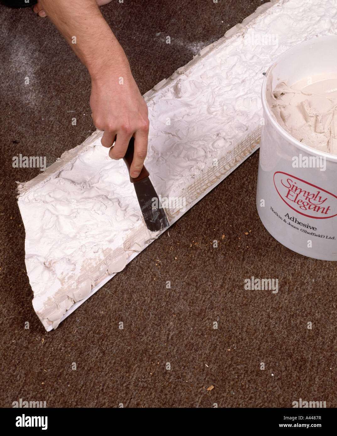 Close Up Of Man Repairing Plaster Ceiling Cornice Stock Photo