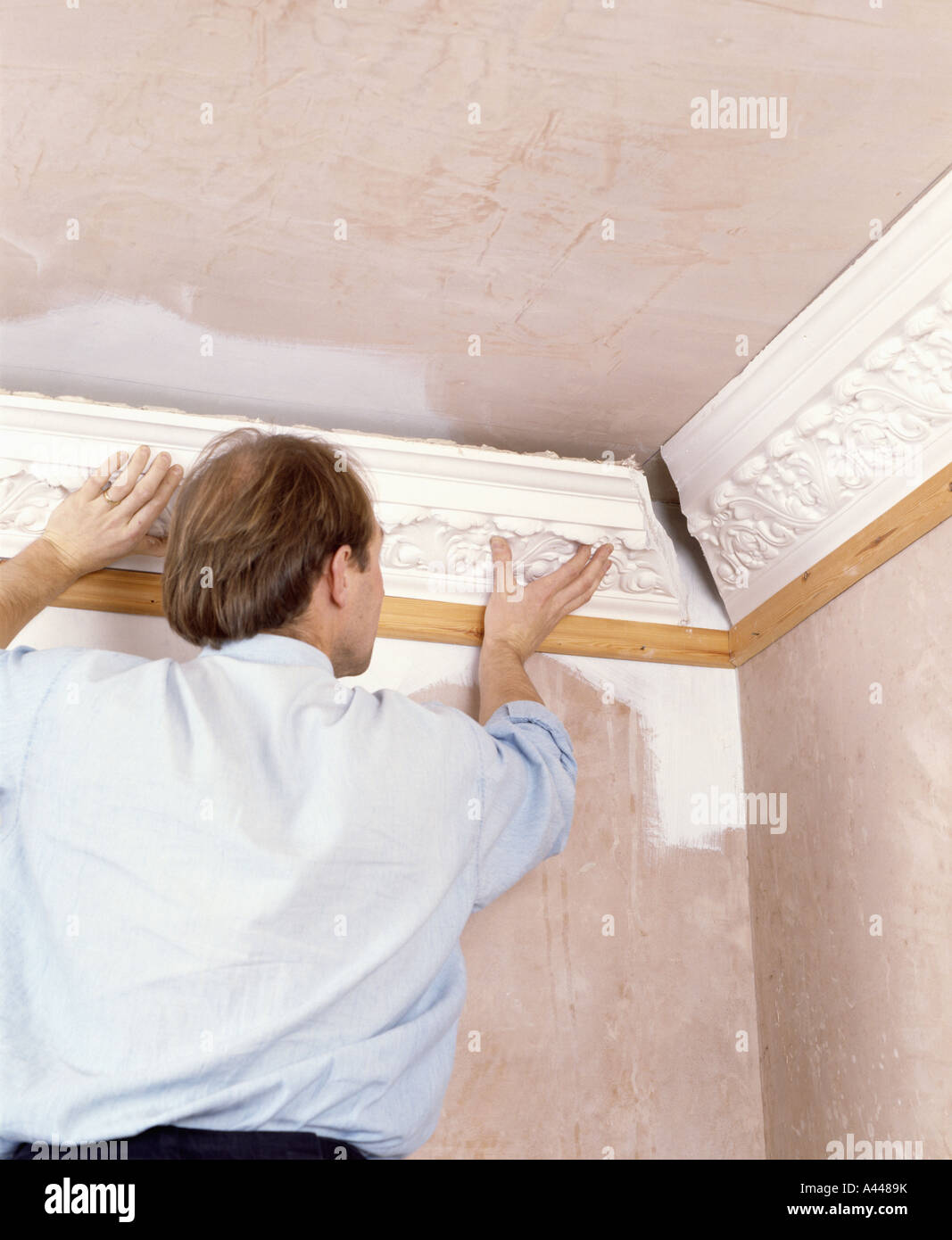 Close Up Of Man Repairing Plaster Ceiling Cornice Stock