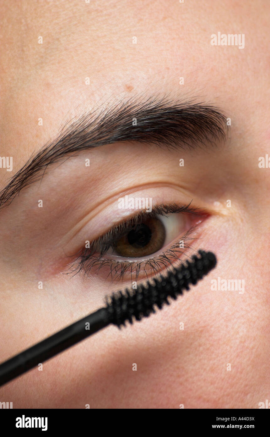 Young woman applying mascara close up Stock Photo