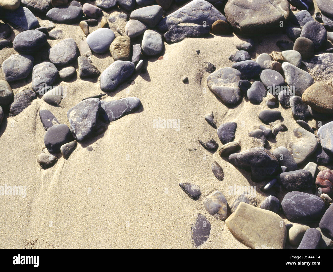 dh SAND BACKGROUND Stone pebbles texture golden sand seashore close up textures backdrop nobody seaside rock Stock Photo