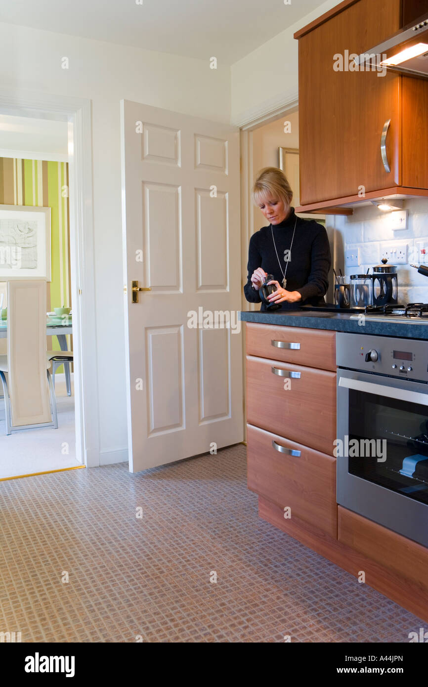 WOMAN WORKING IN A MODERN KITCHEN Stock Photo