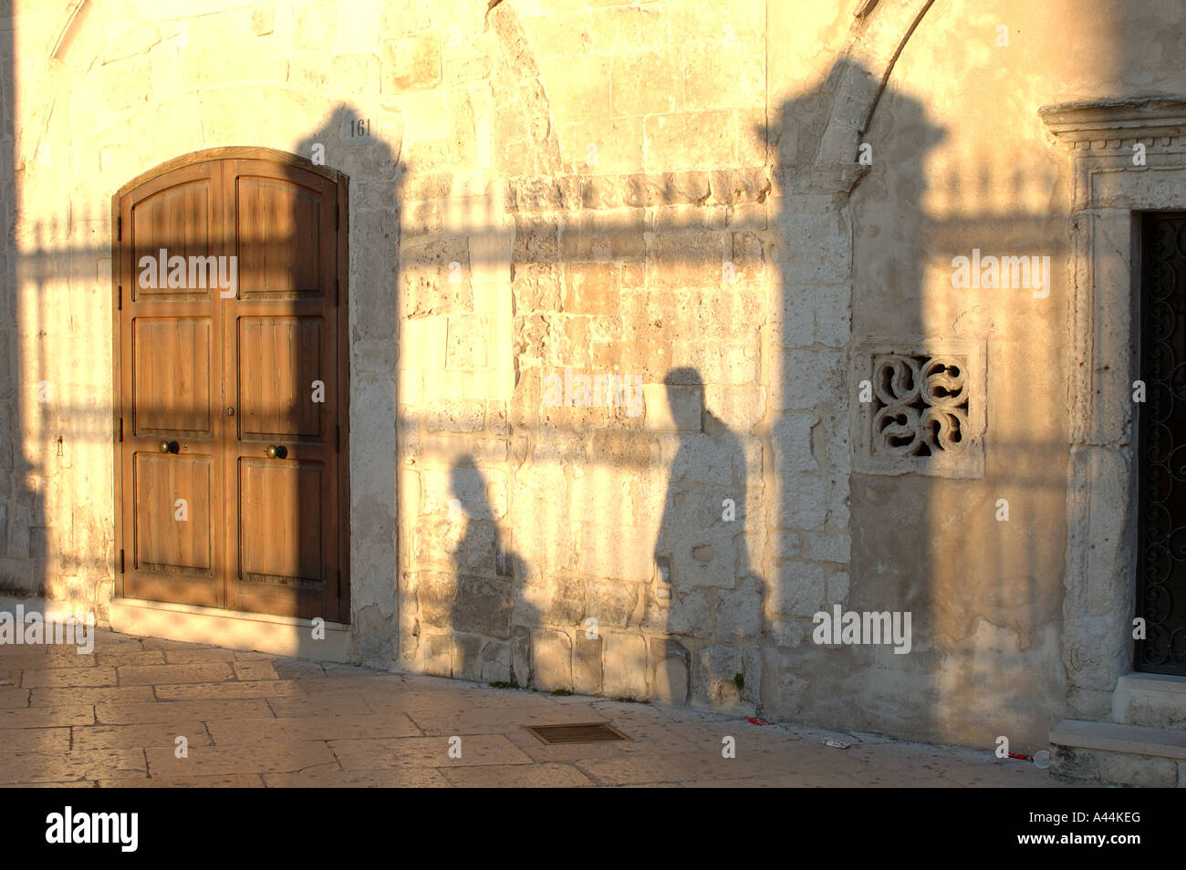 Pilgrim's shadows on the wall of basilica of Archangel Michael, Monte Sant Angelo - Italy. Stock Photo