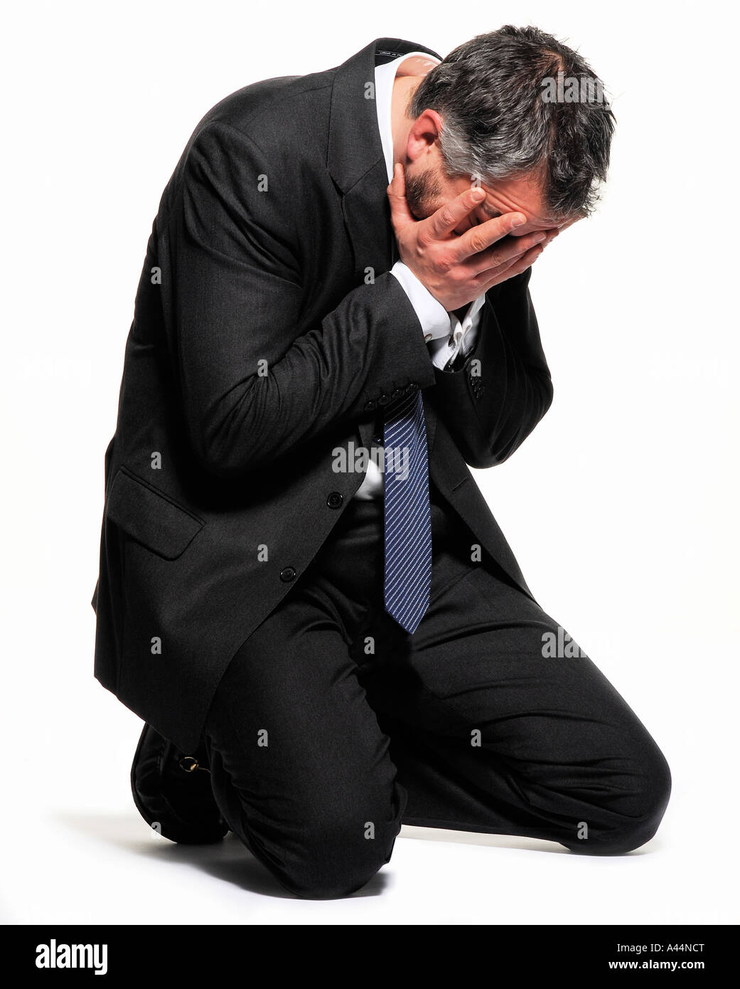 An emotional man sits holding his head with his hands. Picture by Patrick Steel patricksteel. Stock Photo