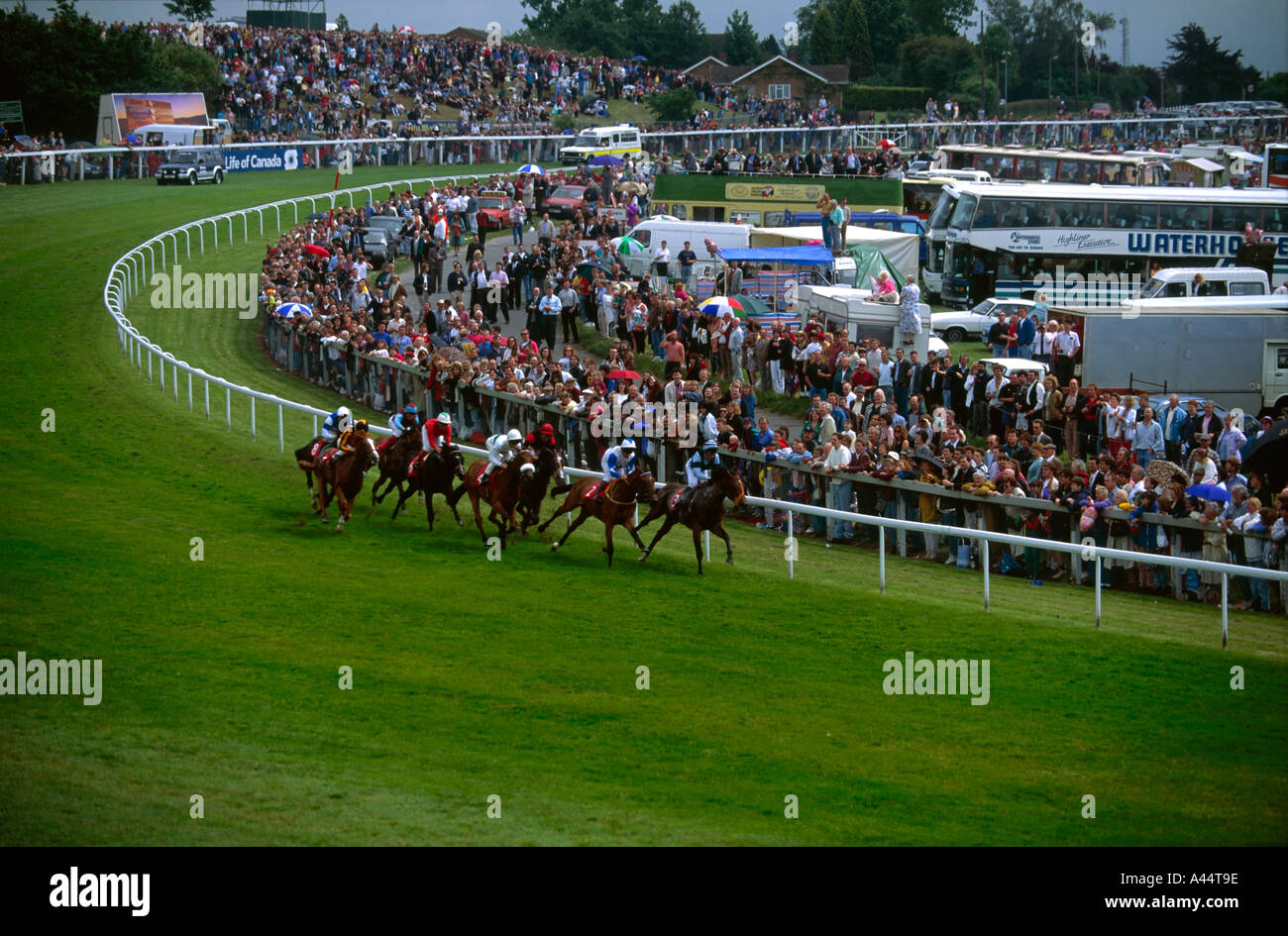 Group of horses race at Tattenham Corner on The Derby horse racing