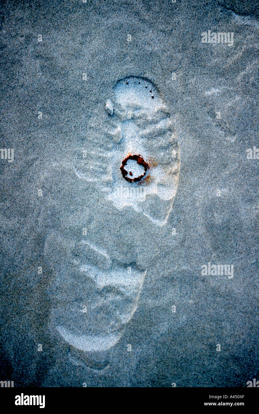 Footprint and rusty bottlecap on windblown beach sand, Pea Island