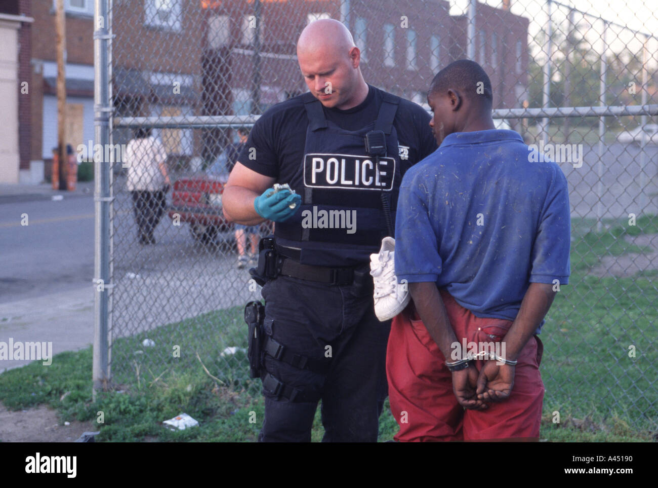 Police officer frisking cuffed suspect. Kansas City, MO, PD, USA Stock