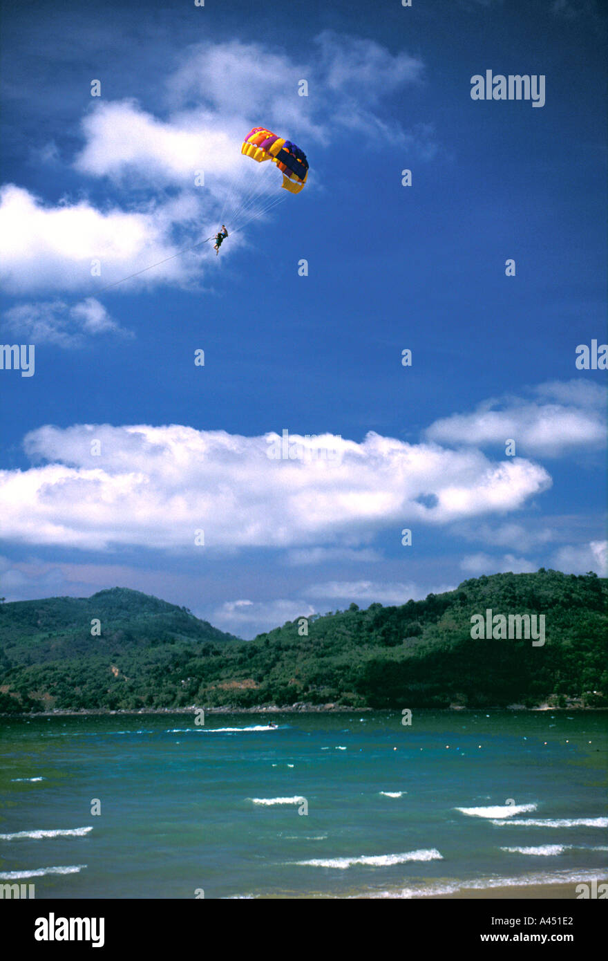 Parasailing high in sky with white clouds behind, Patong Beach, Phuket, Thailand Stock Photo