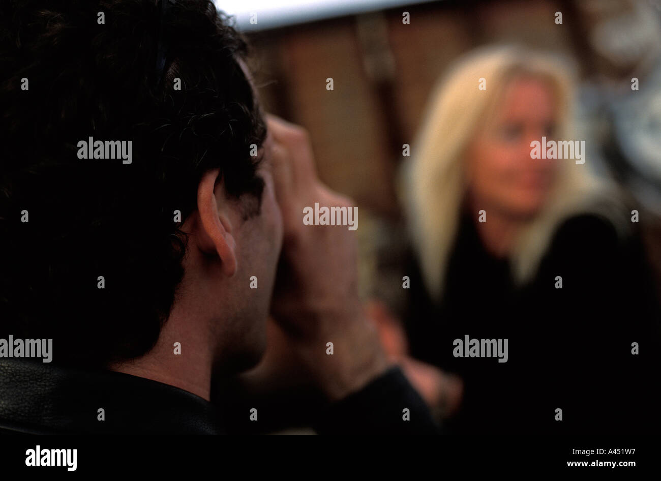 Man photographing woman, over the shoulder, NYC Stock Photo