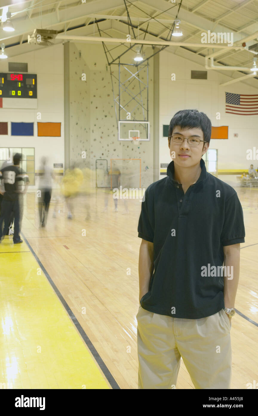 Teenage boy standing on basketball court Stock Photo