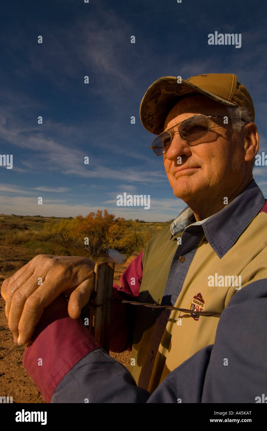 PORTRAIT OF A TEXAS RANCHER LEANING ON A BARBED WIRE FENCE Stock Photo