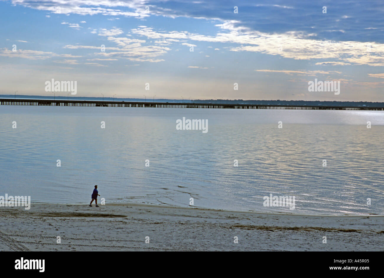 A woman takes an early morning stroll on the beach of Bay Saint Louis Mississippi Stock Photo