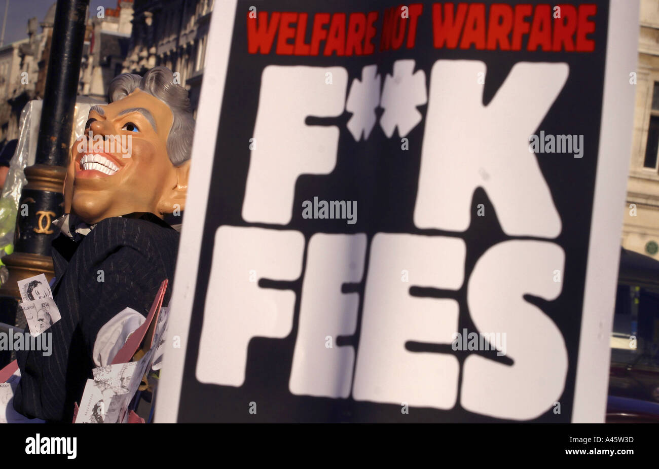 a tony blair mask and banner are displayed during a demonstration by