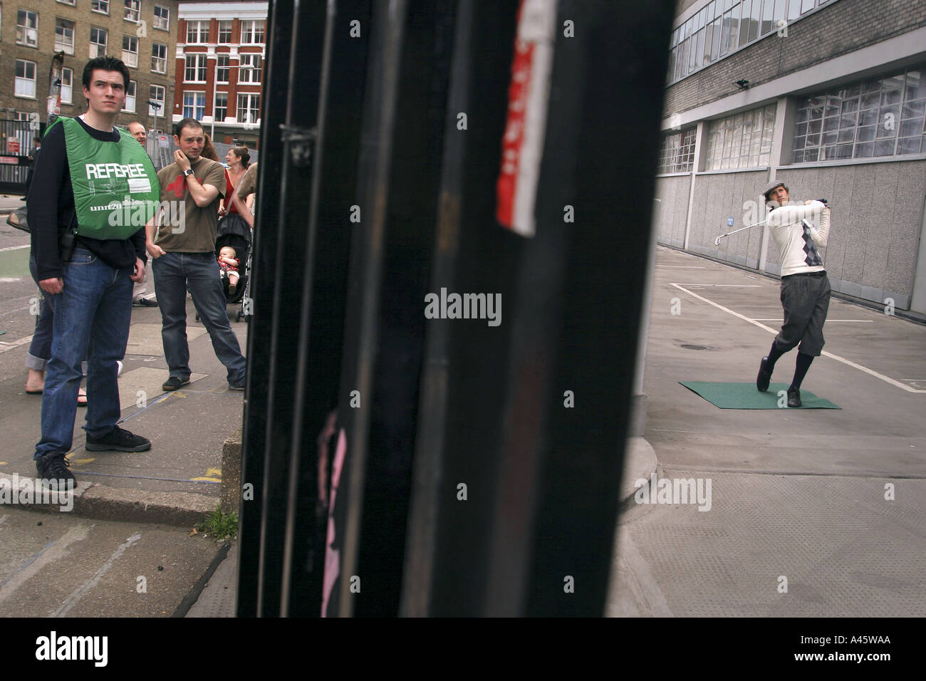 an urban golf competitor tees off in a factory car park at the first shoreditch urban open tournament in london Stock Photo