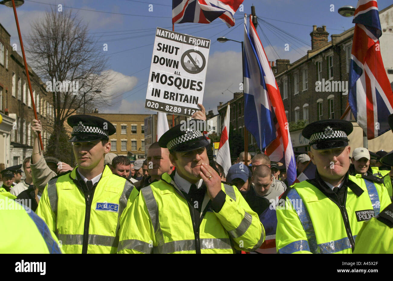 british police officers surround a demonstration by the neo fascist national front party as they picket finsbury park mosque in london april 2004 Stock Photo