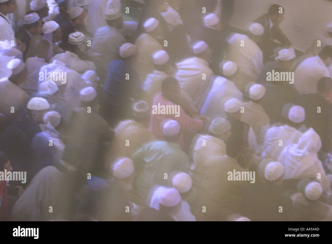 muslim men praying viewed through a window in the the east london mosque in whitechapel in the east end of london Stock Photo