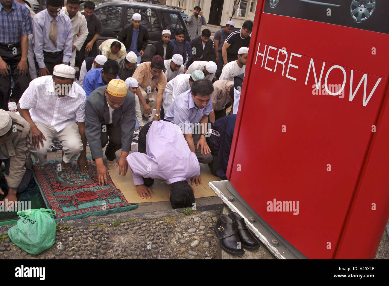 muslim men pray in the street outside the east london mosque in whitechapel in the east end of london Stock Photo