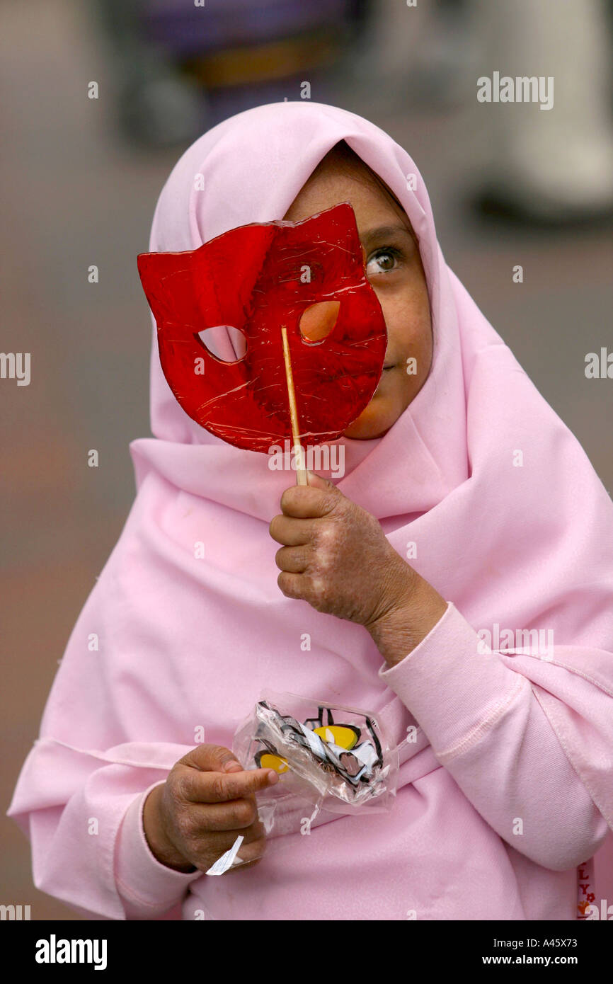 a muslim girl carries a lollipop at a fair to open the new london muslim centre an annex to the east london mosque in whitechapel in the east end of london Stock Photo