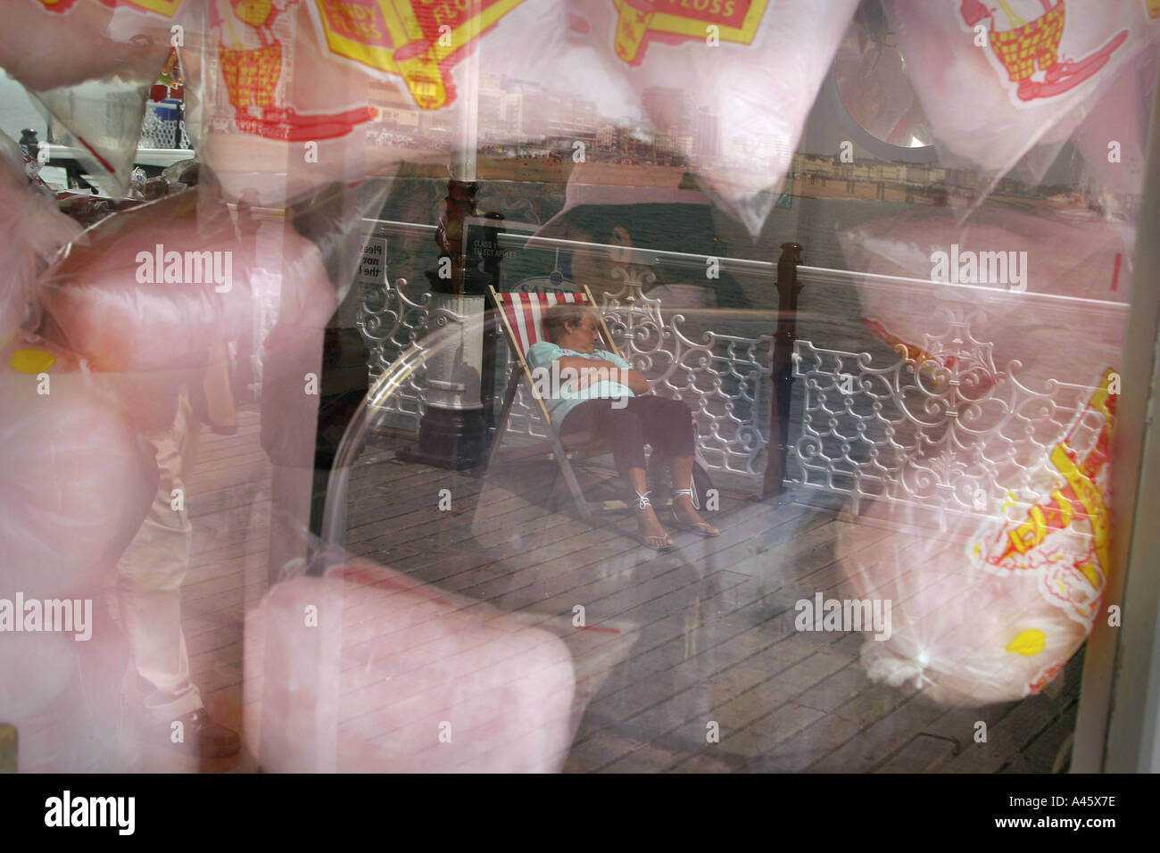 a holidaymaker sleeps on a deckchair on brighton pier on the south coast of england Stock Photo