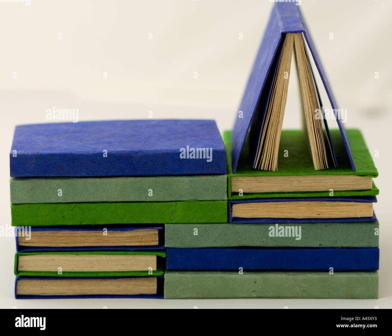 Handmade blue and green booklets neatly piled Stock Photo