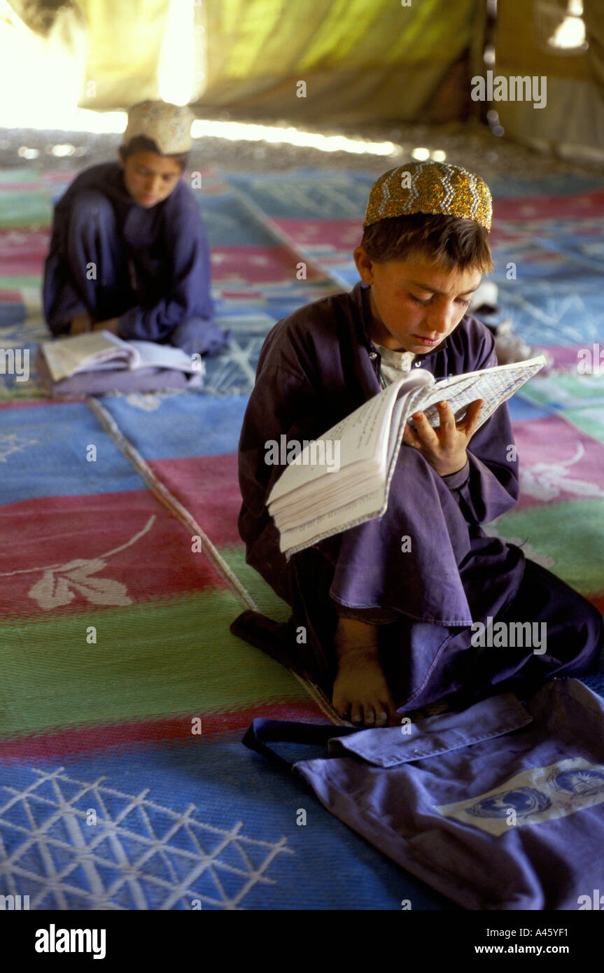 A boy in an internally displaced persons camp called Zahri Dosht near Kandahar reads in an improvised classroon Stock Photo