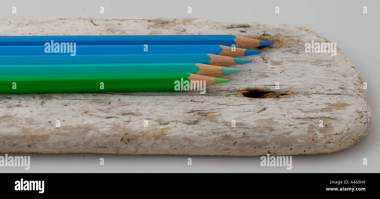Blue and green pencils on a piece of driftwood Stock Photo