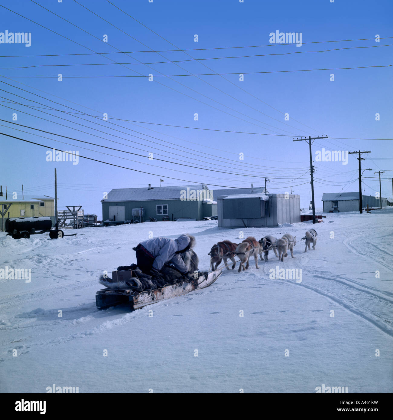 CANADA North West Territory NWT Nunavut Baffin Island Inuit with dog sled in snow by houses Stock Photo