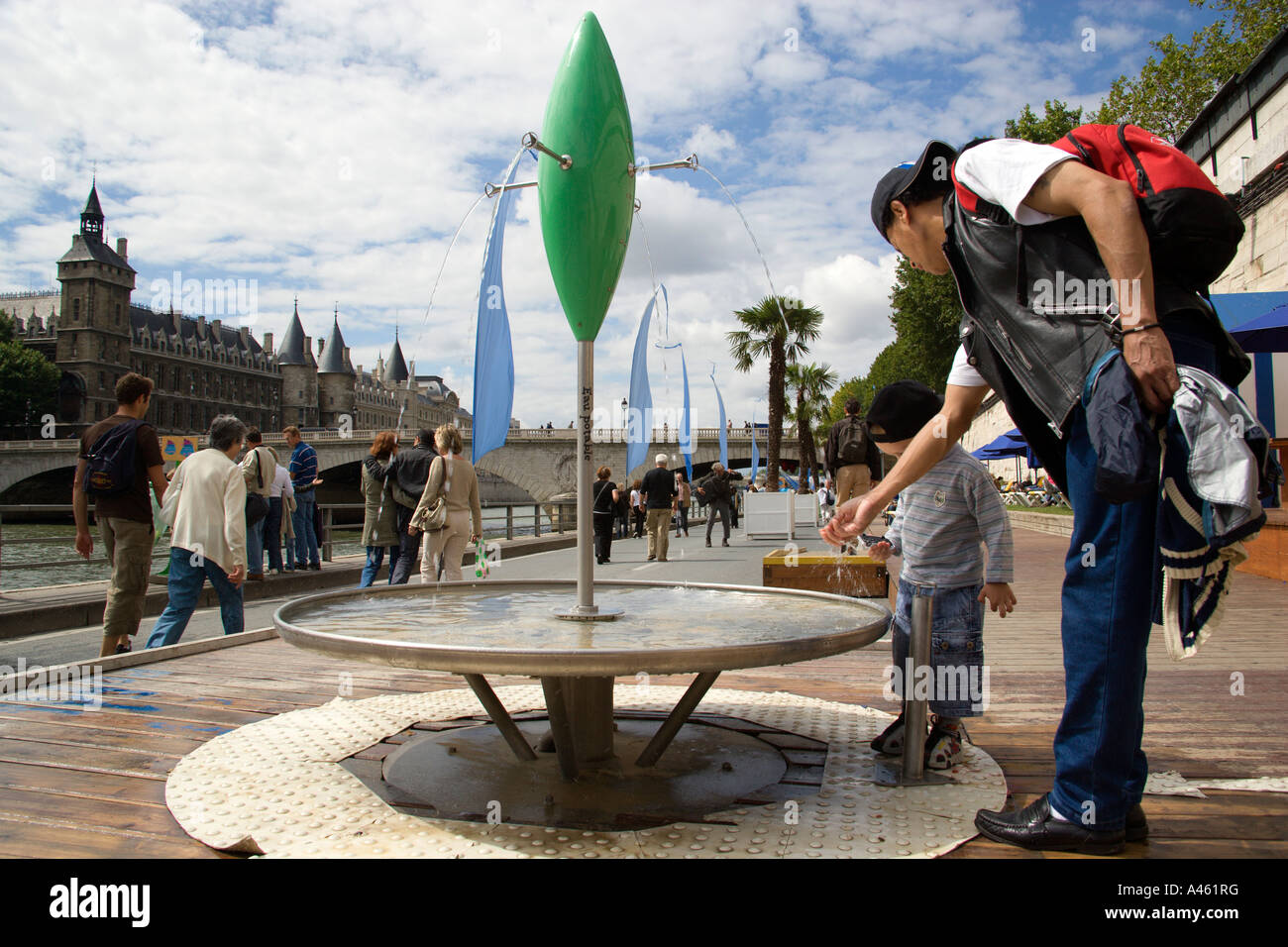 FRANCE Ile de France Paris The Paris Plage urban beach. Man and boy drinking potable water from