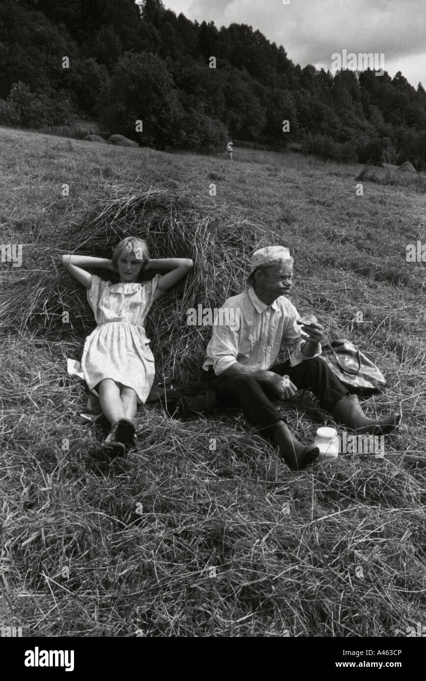 Russian girl and grandfather  taking lunch and resting after cutting hay field. Near Petro-Zavodsk      No 5 Stock Photo