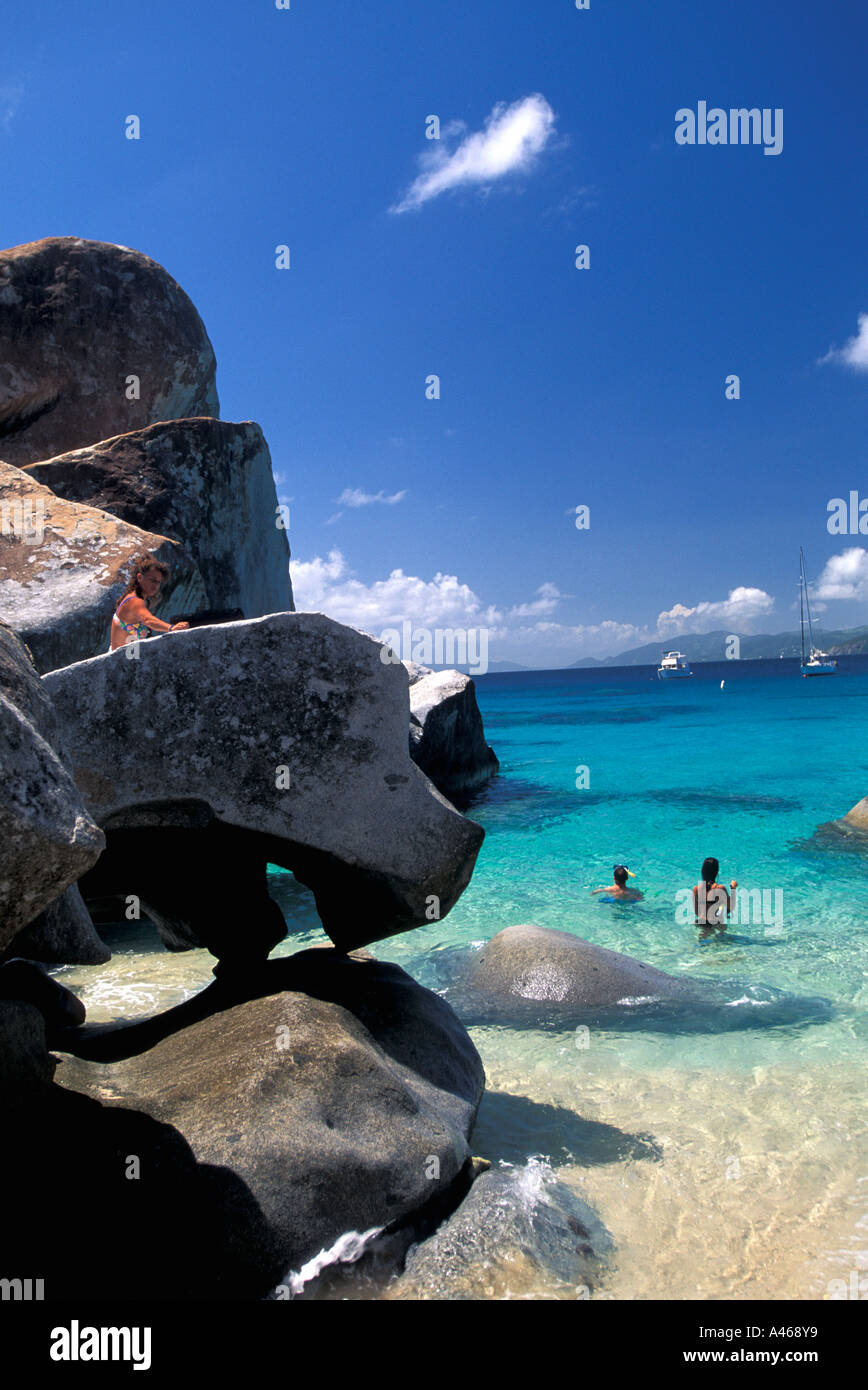British Virgin Islands The Baths Virgin Gorda tourists in water around large granite boulders Stock Photo