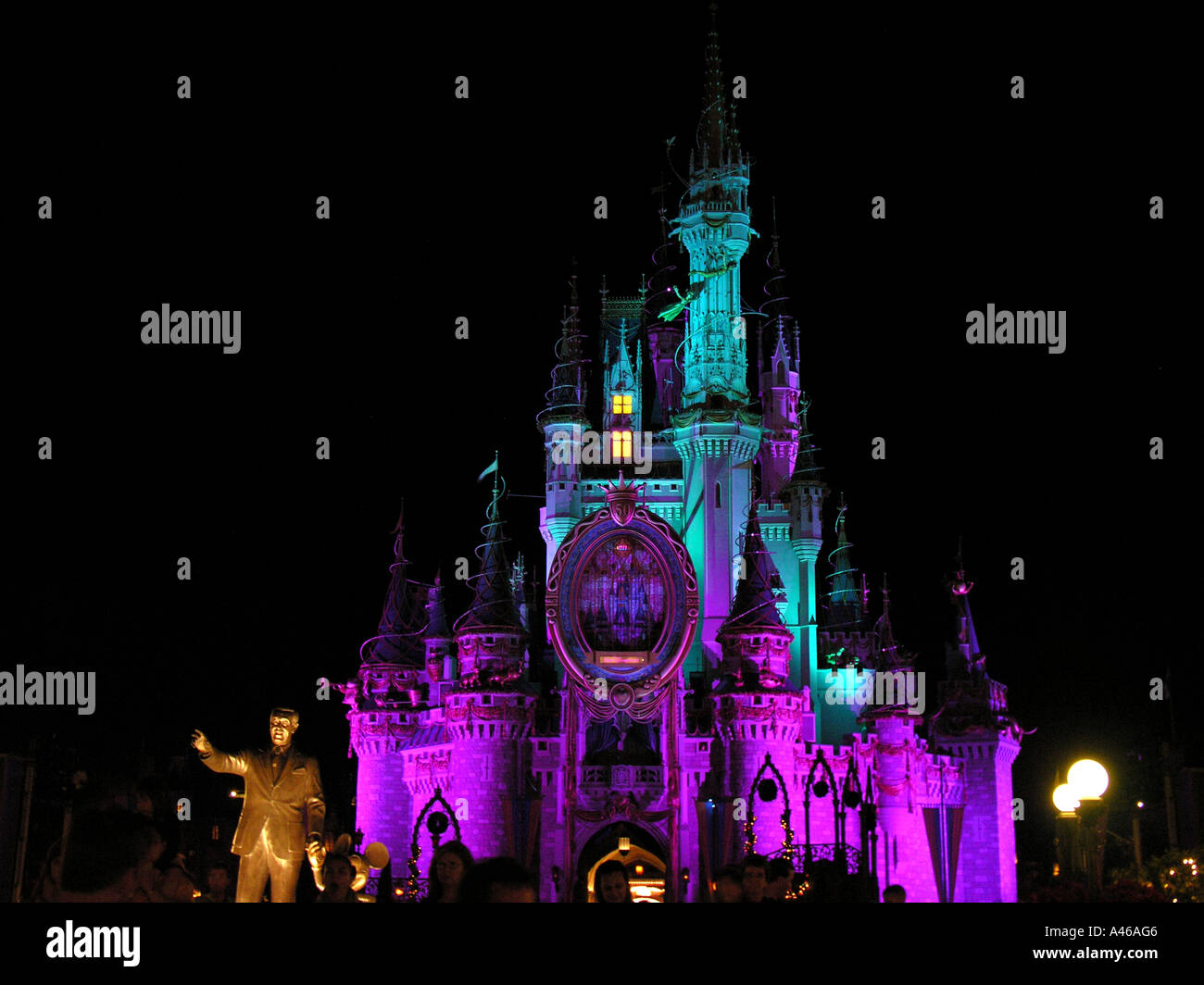 Disney World Magic Kingdom Cinderella Castle at night with Walt Disney statue in foreground Stock Photo