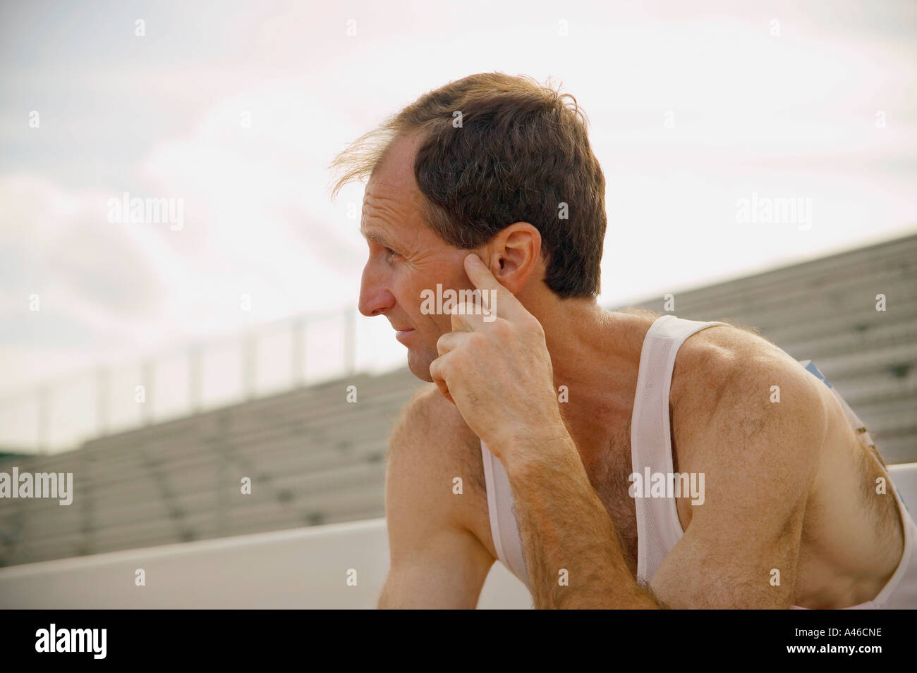 Male athlete sitting in stands Stock Photo - Alamy