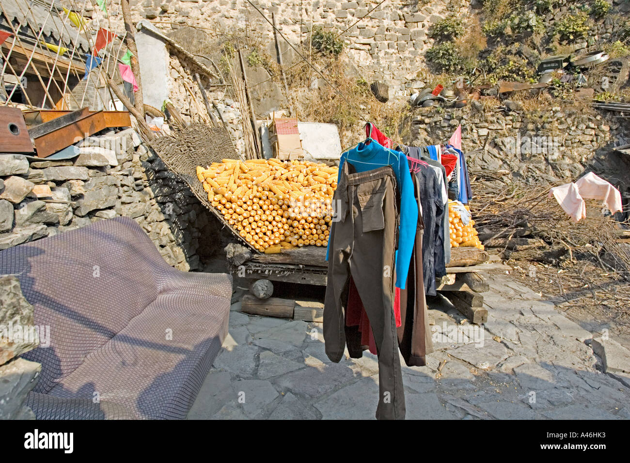 CHINA SIMATAI Clothes drying on a bamboo storage rack full of ears of ...