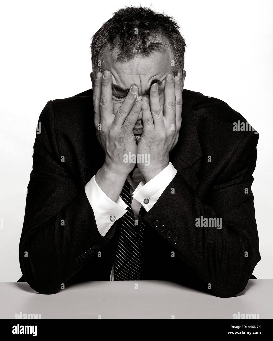 An emotional man sits holding his head with his hands. Picture by Patrick  Steel patricksteel Stock Photo - Alamy