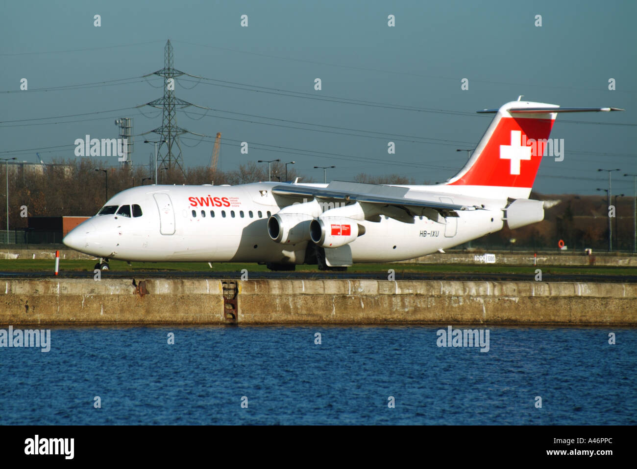Swiss International Airlines aircraft on runway beside redundant King George V dock waters City Airport Silvertown East London England UK Stock Photo