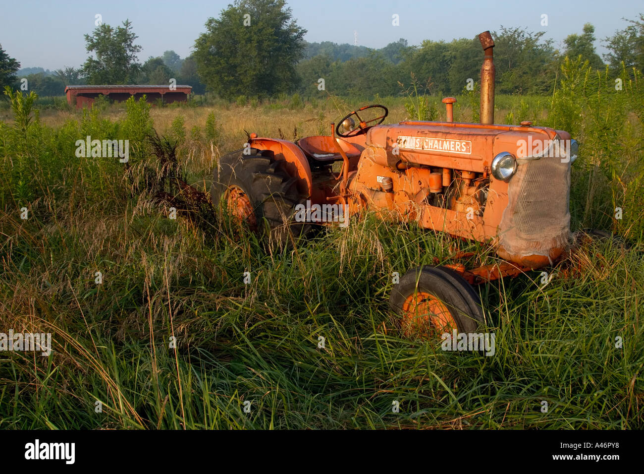 Old abandoned tractor in field of grass Stock Photo - Alamy