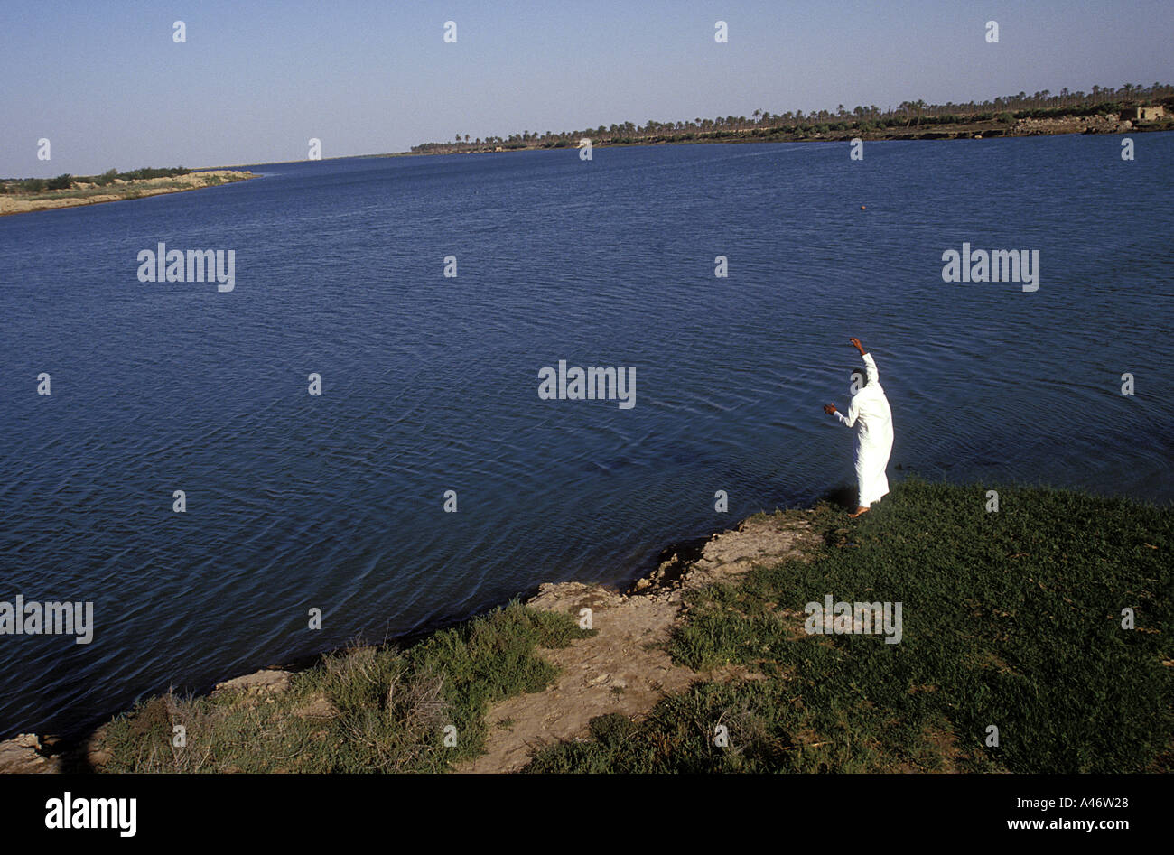 An Iraqi man fishes with a line at the confluence between the Tigris and Euphrates rivers called Al-Qurnah (Qurna) Basra, Iraq Stock Photo