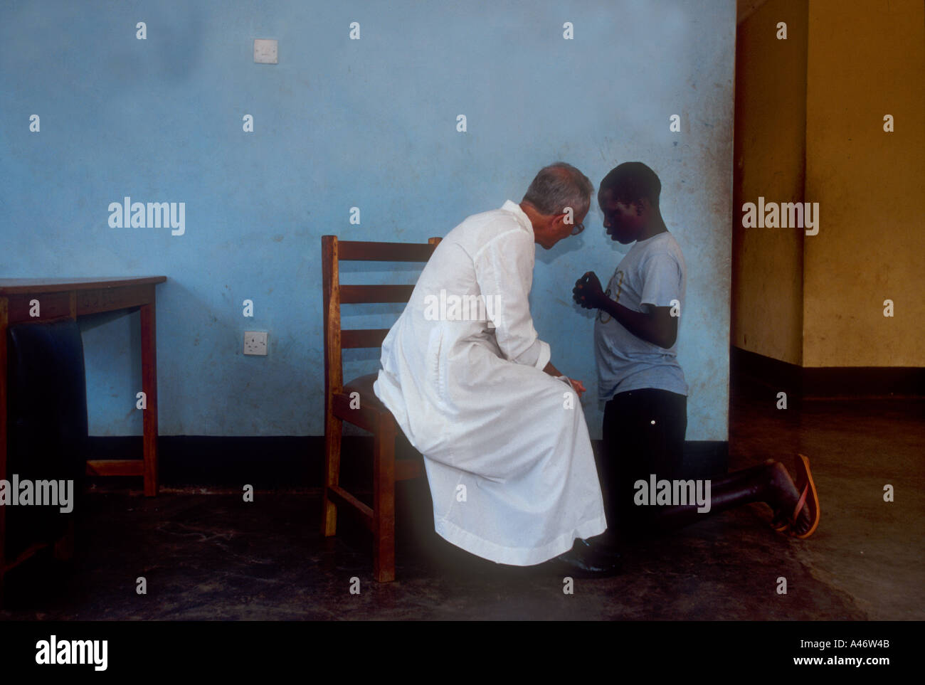 A boy abductee fighter from the Lords Resistance Army receives confession from a Catholic priest in Gulu, Northern Uganda Stock Photo