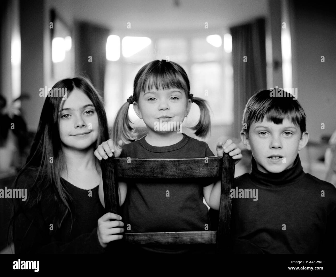 Black and white family portrait of three children Stock Photo