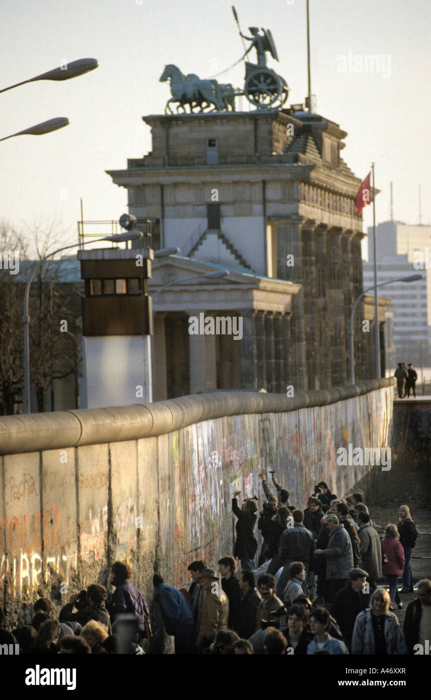 Fall of the Berlin Wall: people chiselling pieces off the Wall at the Brandenburg Gate (Mauerspecht), Berlin, Germany Stock Photo